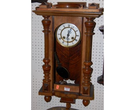 An early 20th century walnut droptrunk wall clock