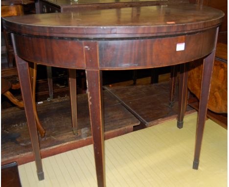 An early 19th century mahogany satinwood crossbanded and further strung demi-lune fold over card table, on square cut taperin