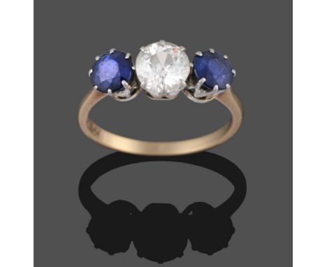 A Sapphire and Diamond Three Stone Ring, the old cut diamond flanked by two round cut sapphires in white claw settings, to a 