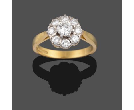 An 18 Carat Gold Diamond Cluster Ring, the central round brilliant cut diamond sits above a row of eight smaller round brilli