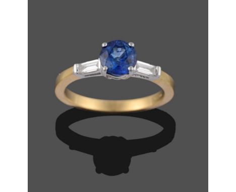 An 18 Carat Gold Sapphire and Diamond Three Stone Ring, the round mixed cut sapphire in a white four claw setting to shoulder