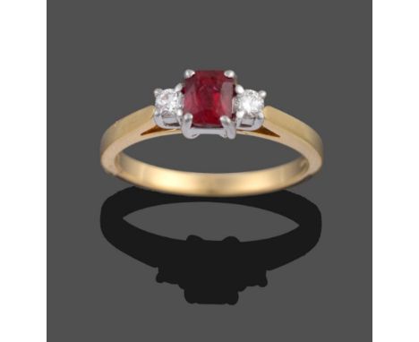 An 18 Carat Gold Ruby and Diamond Three Stone Ring, the modified emerald-cut ruby sits between two round brilliant cut diamon