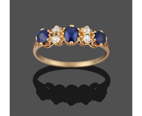 A Sapphire and Diamond Ring, an oval cut sapphire flanked by pairs of old cut diamonds to a round cut sapphire either side, i