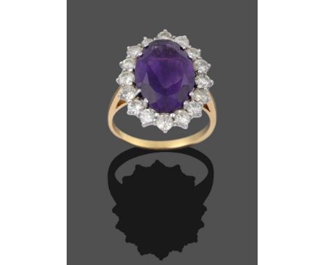 An 18 Carat Gold Amethyst and Diamond Cluster Ring, the oval cut amethyst in a white double claw setting, within a border of 