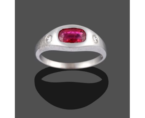 An 18 Carat White Gold Ruby and Diamond Three Stone Ring, the cushion cut ruby and two round brilliant cut diamonds drill set