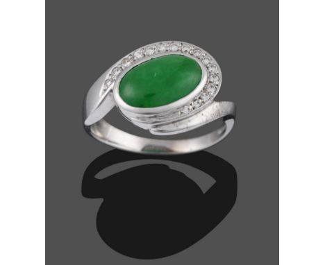 An 18 Carat White Gold Jade and Diamond Ring, an oval cabochon jade in a collet setting with a row of diamond accents three q