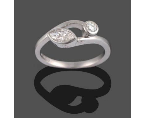 A Platinum Diamond Two Stone Cross-Over Ring, a marquise cut diamond and a round brilliant cut diamond in rubbed over setting