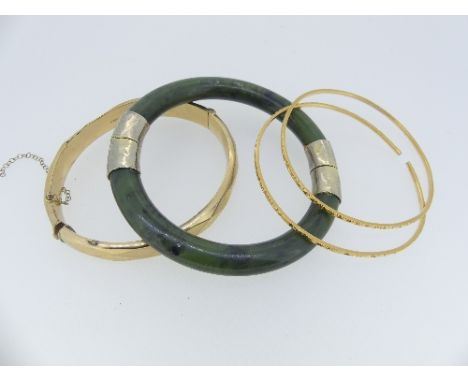 A 9ct yellow gold hinged hollow Bangle, 13.6g, together with a jade hinged bangle, with white metal mounts, and two gold slav