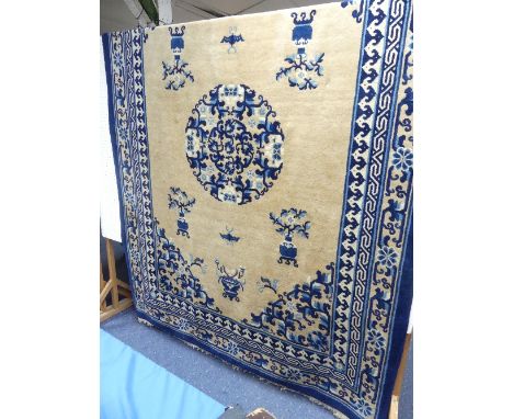 An antique Chinese Peking Carpet, the beige ground with dark blue, light blue, cream and pale pink butterfly and vase designs