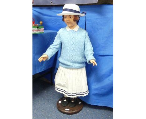 A Large Child Mannequin from Fields of Sidmouth, solid composition and painted face on wooden stand fully dressed in  outfit.