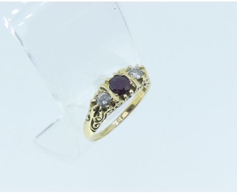 A ruby and diamond three stone Ring, the central facetted ruby with a diamond on each shoulder, in a carved gallery, all moun