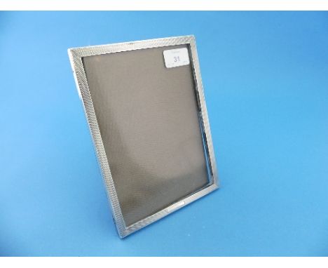 A George VI silver Easel Frame, hallmarked Birmingham, 1939, of rectangular form with engine turned decoration, wooden easel 