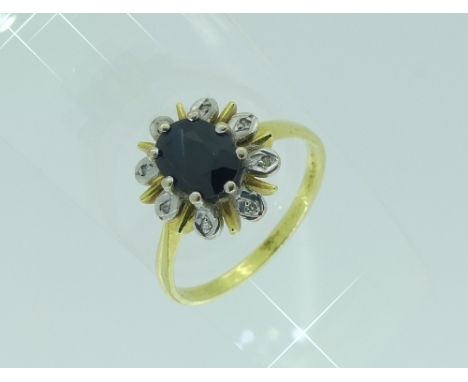 A sapphire and diamond Cluster Ring, the the oval sapphire with eight white petals around each set diamond point and with yel