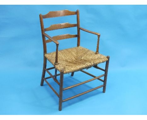 An antique provincial elm and ash ladder back Arm Chair, with rush seat.