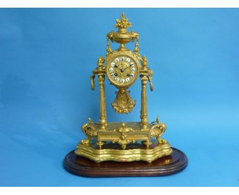 A French Empire ornate gilt-metal pillar Mantel Clock, with stand and glass dome, the circular dial surmounted by a flowering