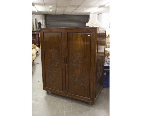 A CHINESE CARVED MAHOGANY TWO DOOR CABINET 