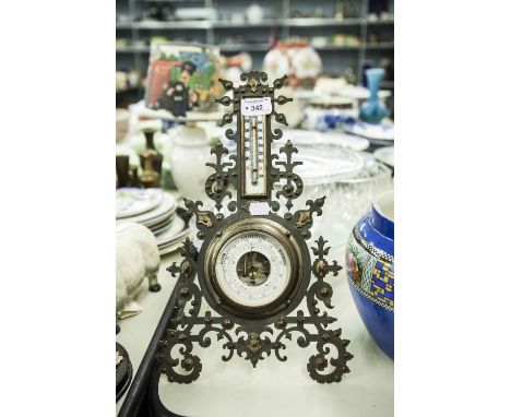 A METAL CASED ANEROID BAROMETER AND THERMOMETER ON STAND 