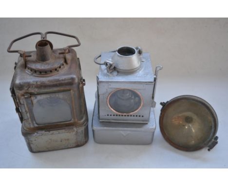 Two railway lamps (1 repainted silver, other with a cracked pane) and a vintage motorbike headlight. (3) 