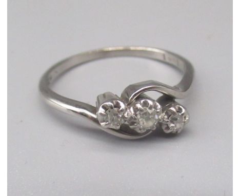 Platinum three stone diamond ring, the brilliant cut illusion set diamonds on twist mount, stamped PLAT, size Q, 3.4g 