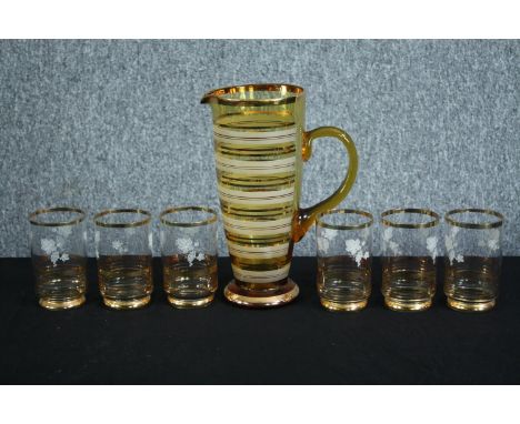 A vintage water jug and six matching glasses. The cups with a matching floral motif. H.27cm. (largest) 