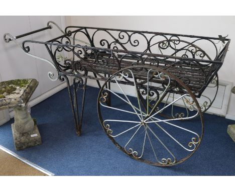 A wrought iron wheelbarrow planter, W.170cm