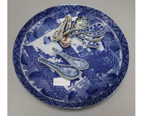 A large Japanese blue and white charger and a collection of ceramic spoons
