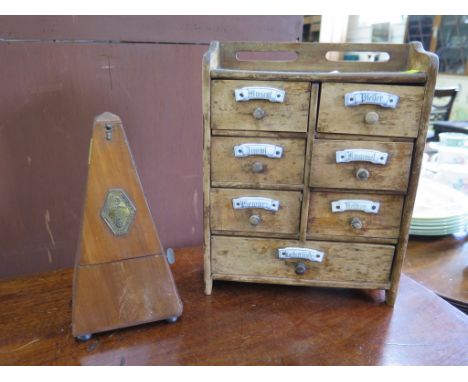 A German pine spice cabinet, with porcelain plaques, 29cm high, 22.5cm wide, and a metronome