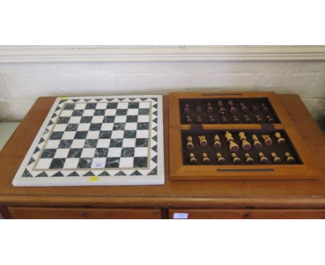 A good marble inlaid chess or draughts board of various colours 41cm x 41cm and a cased chess set
