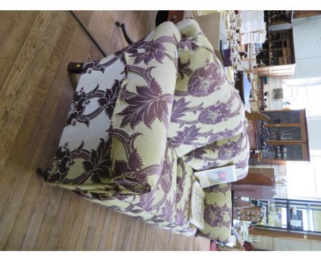 A Duresta three seat sofa in purple foliate motif upholstery on turned legs and castors 240cm long