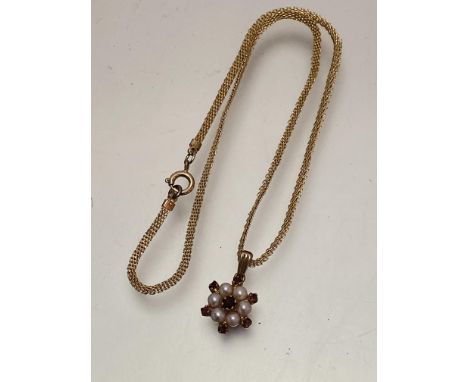 A 9ct gold garnet and seed pearl cluster pendant on yellow metal trace link chain, (pendant approximately 1.5cm diameter) sta