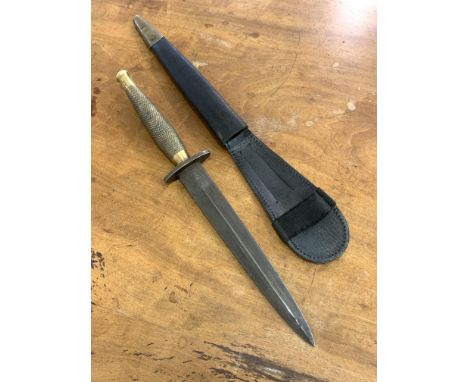 A Reproduction of a Fairburn Sykes Fighting knife, the brass handle stamped with broad arrow, in leather sheath L31cm