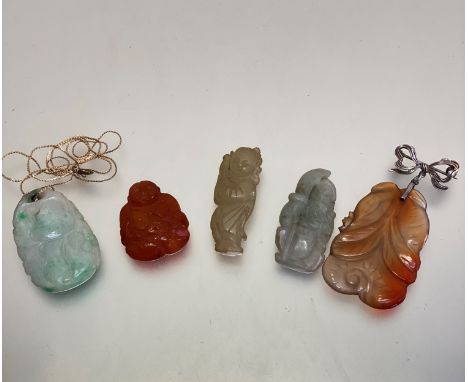 A group of five various coloured jade and carved hard stone Chinese pendants including pale celadon and green dyed jade penda