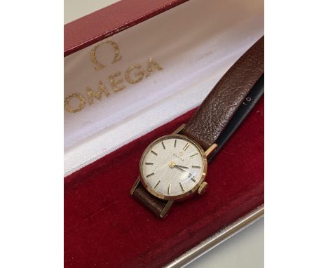 A lady's Omega 9ct gold manual wristwatch with baton hour markers, on leather strap (d.2cm), inscription verso, complete with