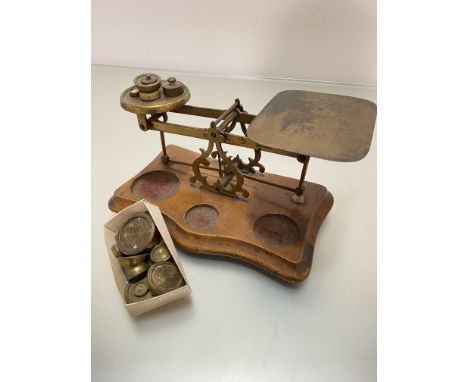 A set of postal style postmaster's letter scales complete with a collection of various weights mounted on serpentine mahogany