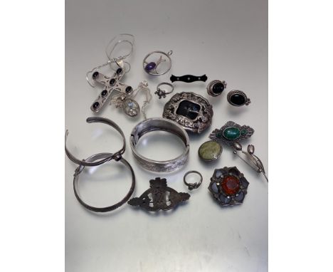 A collection of silver and white metal jewellery including an Edwardian engraved stiff hinged bangle, a white metal bangle, a