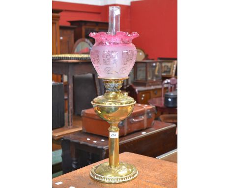 A Victorian brass oil lamp, acid etched cranberry flashed shade, Duplex twin burner (converted for electricity)