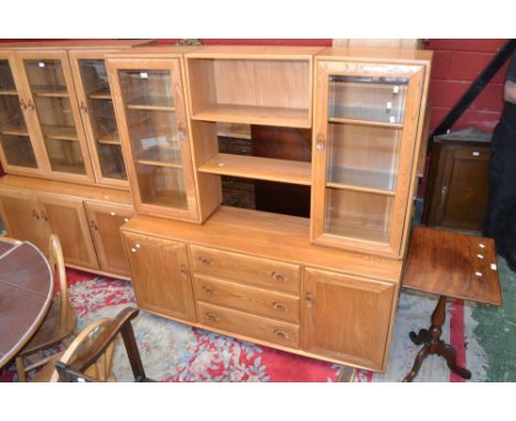 An Ercol bookcase, glazed panel doors, open shelves to centre