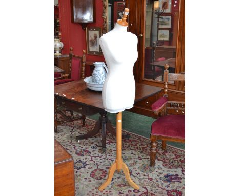 A shop mannequin, female torso, adjustable tripod base  