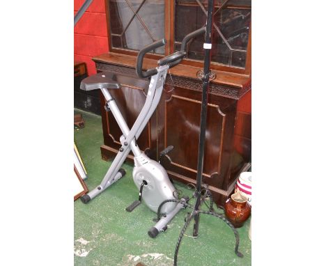 A metal work standard lamp; a modern exercise bike