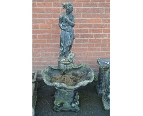 A cast garden fountain of classical form, scantily clad girl, scallop shell basin, inverted ionic column base.