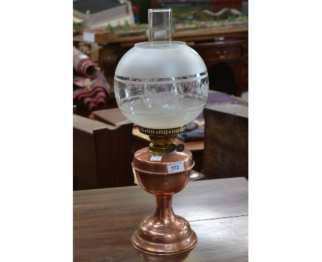 An Edwardian copper and brass paraffin oil lamp, etched globular shade and chimney