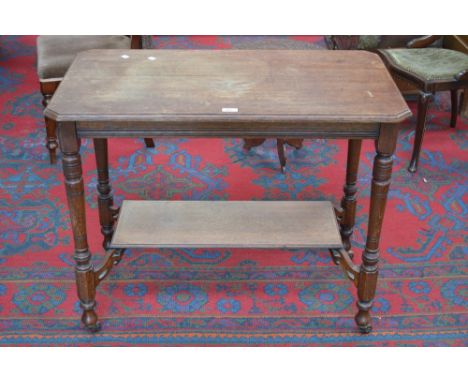 A Victorian oak two tier centre table, turned supports, ceramic casters, circa 1860.