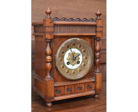 A walnut cased mantel clock, brass chapter ring, Arabic numerals, turned columns.
