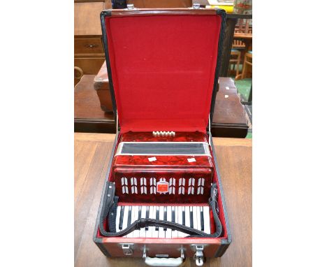 A "Bai-Le" red marble effect Piano Accordion, with travelling case