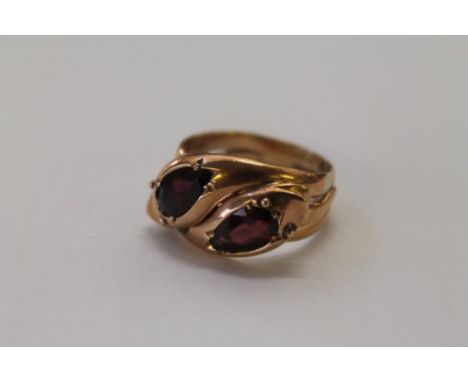 Rose gold (9ct) snake ring, modelled as two intertwined snakes, each with a pear cut garnet (Birmingham 1912).  Ring size R½ 