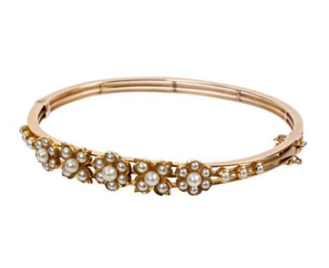 Victorian hinged bangle with five seed pearl flower-head clusters in yellow metal setting, stamped '15' CONDITION REPORT Appr
