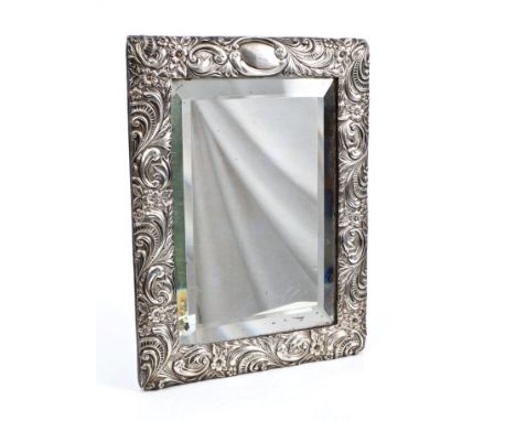 Edwardian silver mounted desk / dressing table mirror with raised scroll and foliate decoration, bevelled mirror plate and le