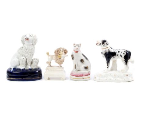 Early 19th century Derby porcelain dog ornament with black patch and spot decoration, 12cm, two Victorian Staffordshire poodl