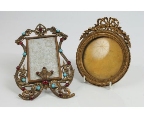 Late 19th century French gilt metal photograph frame of circular form, with ribbon-tied surmount, stamped verso 'Benque & Co.