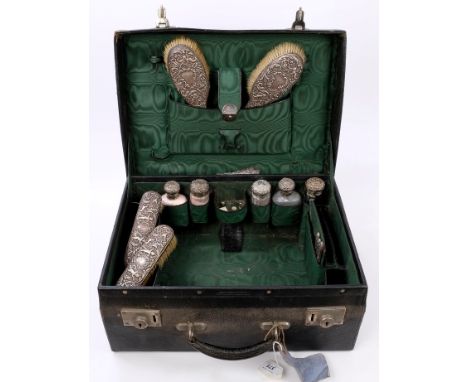Edwardian leather travelling case with fitted green silk interior, containing a selection of silver mounted toilet bottles, t